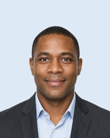 Example CV / LinkedIn photo (4:5): a man in a charcoal jacket and light blue shirt, light blue background (fictional AI-generated model)