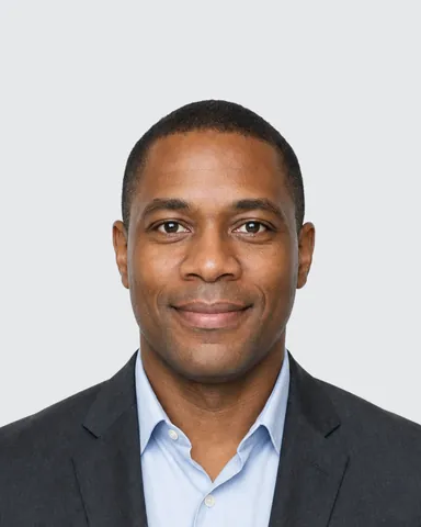 Example CV / LinkedIn photo (4:5): a man in a charcoal jacket and light blue shirt, light grey background (fictional AI-generated model)